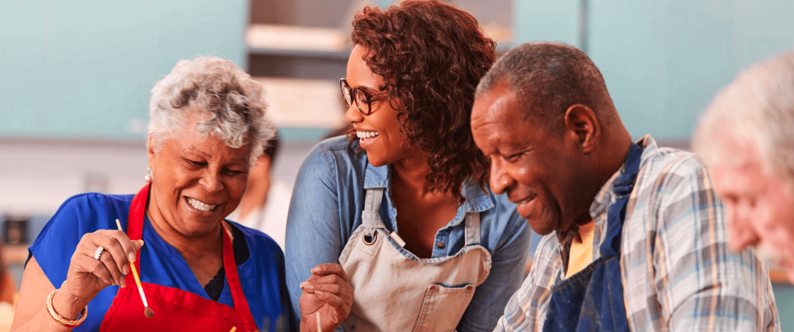 Employee helping seniors in a painting class